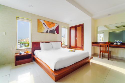 a bedroom with a large white bed and a window at Hotel Soco in Da Nang