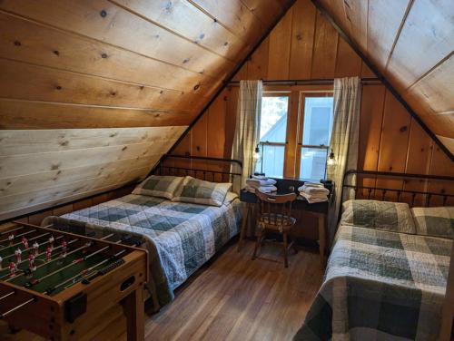 a attic bedroom with two beds and a chess board at Cabin #8 in Strawberry