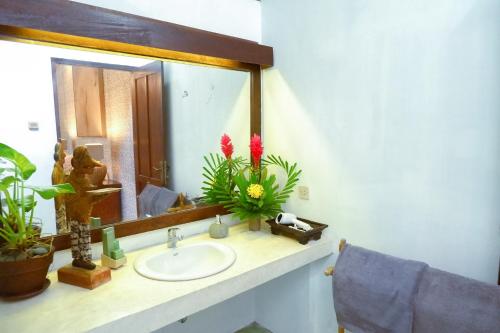 a bathroom with a sink and a mirror at D'omah Yogya Hotel in Yogyakarta