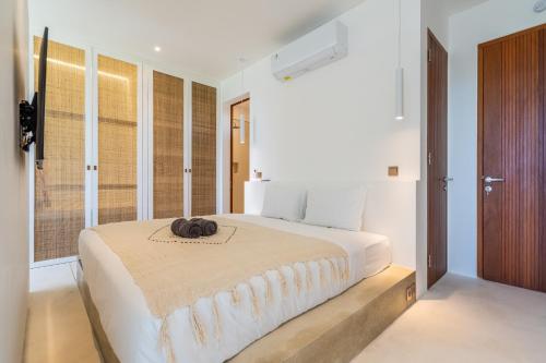 ein Schlafzimmer mit einem großen Bett mit Hut darauf in der Unterkunft Sore Apartment by Hombali in Canggu