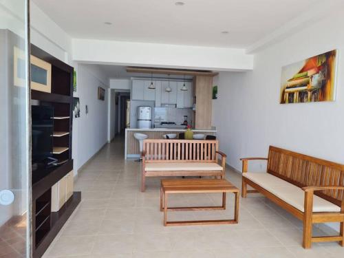 un salon avec deux bancs et une cuisine dans l'établissement Apartamento familiar de lujo 104, à San Bartolo
