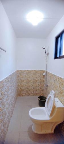 a bathroom with a toilet in a room at RNA Guesthouse in Moalboal