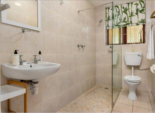 a bathroom with a sink and a toilet and a shower at Valley Heights Guest House and B & B in Cape Town