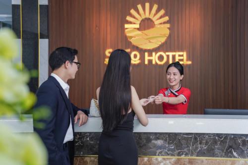 a man and a woman standing in front of a hotel at Hotel Soco in Da Nang