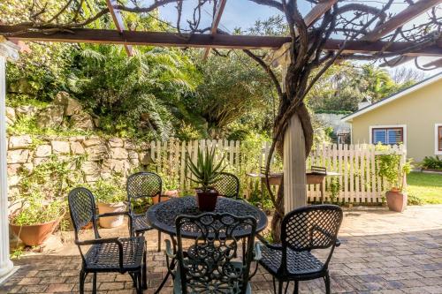 a patio with a table and chairs under a pergola at Valley Heights Guest House and B & B in Cape Town