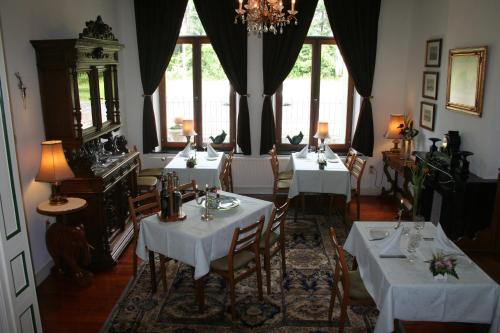 una sala da pranzo con 4 tavoli con tovaglia bianca di Hotel Beukenhorst a Wittem