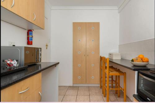 a kitchen with wooden cabinets and a counter top at Valley Heights Guest House and B & B in Cape Town