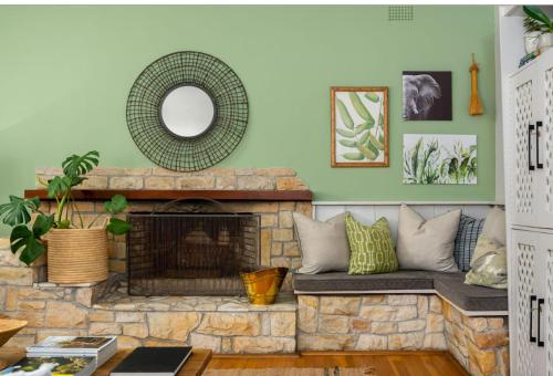 a living room with a stone fireplace and a mirror at Valley Heights Guest House and B & B in Cape Town