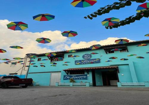 a group of umbrellas flying in the air outside a building at Pousada La Riviera - Pé na areia e Passeios em Maragogi in Maragogi