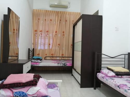 a room with two beds and two bunk beds at Homestay HARAPAN in Muar