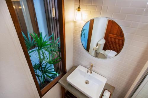 W łazience znajduje się umywalka i lustro. w obiekcie Phang Nga Origin Hotel w mieście Phangnga