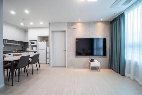 大田的住宿－Sai，厨房以及带桌子和电视的用餐室。