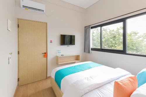Ένα ή περισσότερα κρεβάτια σε δωμάτιο στο Sans Hotel Clover Ace Surabaya by RedDoorz