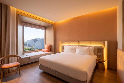 a hotel room with a bed and a window at Centara Ubon in Ubon Ratchathani