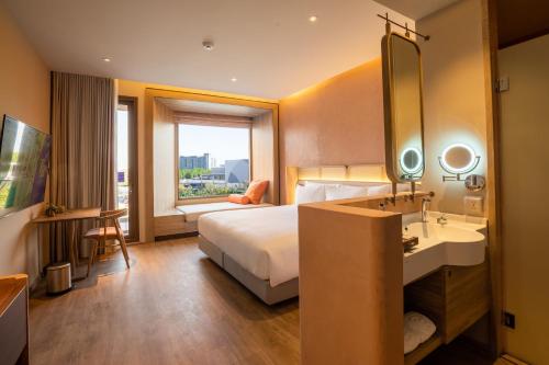 a hotel room with a bed and a sink and a mirror at Centara Ubon in Ubon Ratchathani
