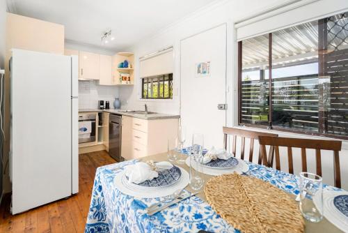 a kitchen and dining room with a table and chairs at Surfs Up! Oceanfront Home Sleeps 6 steps from the sand in Emerald Beach