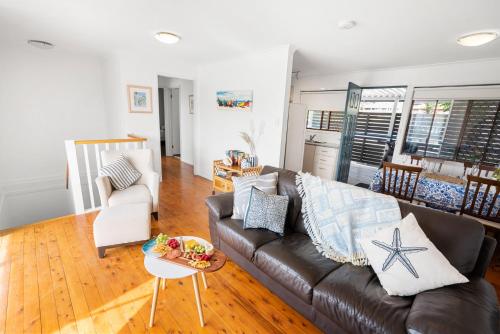 a living room with a couch and a table at Surfs Up! Oceanfront Home Sleeps 6 steps from the sand in Emerald Beach
