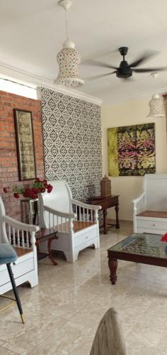 a living room with a bed and a ceiling fan at Laman Zavilla Dhoma 1 in Sungai Pelik