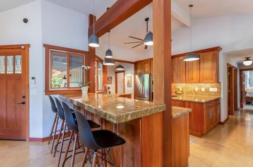 a kitchen with a large island with blue bar stools at Makana Lei in Princeville