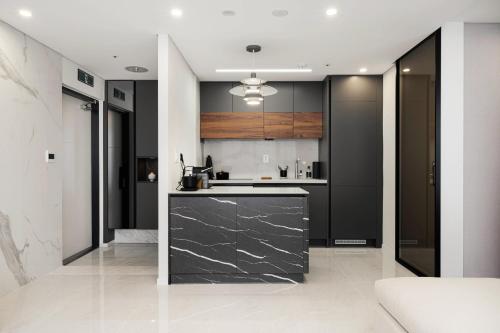 a kitchen with black cabinets and a counter top at Le Collective Gangnam SAC Signity in Seoul