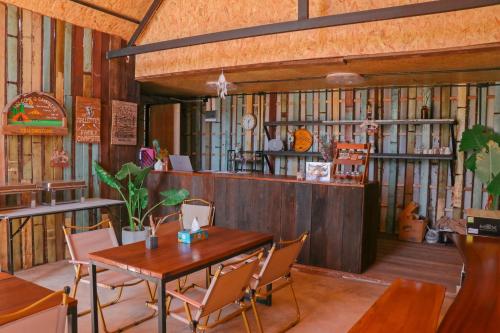 un restaurante con mesa y sillas en una habitación en Yellowstone Camps Resort Khao Yai en Pak Chong