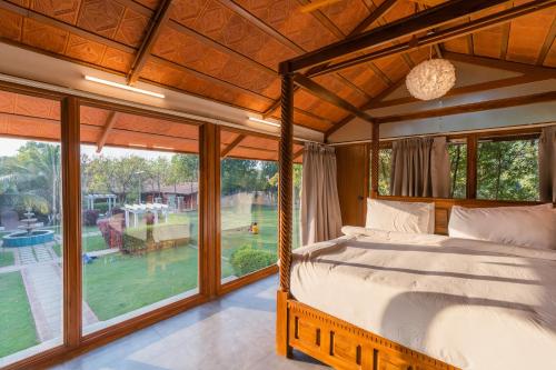 a bedroom with a bed and a large window at Brown Town Resort & Spa in Hyderabad