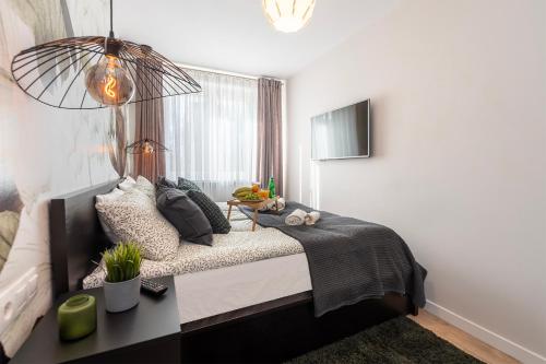 a bedroom with a bed and a window at Golden Sands - Winda, 2 Sypialnie oraz Salon, Łóżeczko Turystyczne, Balkon, Play Station 5, Ekspress do Kawy, Atlas Arena, ZOO, Fala in Łódź