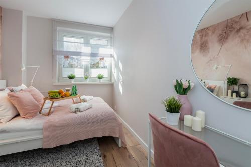 a small bedroom with a bed and a mirror at Golden Sands - Winda, 2 Sypialnie oraz Salon, Łóżeczko Turystyczne, Balkon, Play Station 5, Ekspress do Kawy, Atlas Arena, ZOO, Fala in Łódź