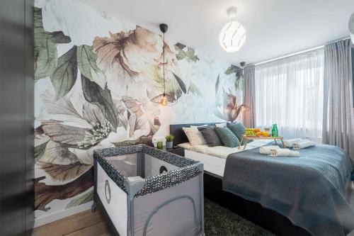 a bedroom with a flower mural on the wall at Golden Sands in Łódź