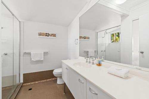 uma casa de banho branca com um lavatório e um WC em Coco Bay Resort em Noosaville