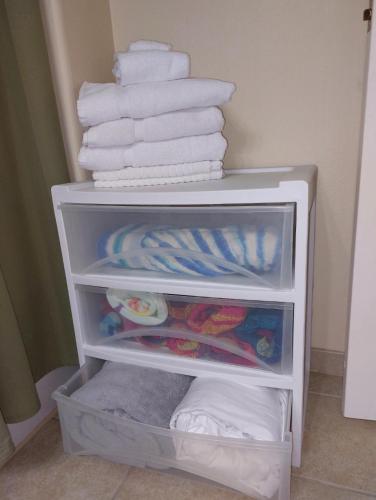 a white cabinet filled with towels and towels at Disney 1 mile , Blue Heron 1 room 2 bath,amenities,6 guests, walk to restaurants, no fees at check in in Orlando