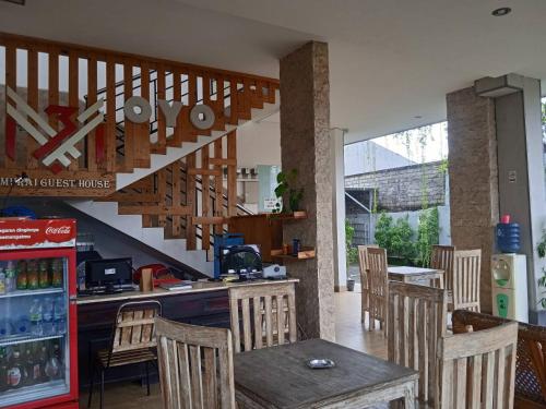 een keuken met een tafel en stoelen en een trap bij MURAI Guesthouse Bali in Denpasar