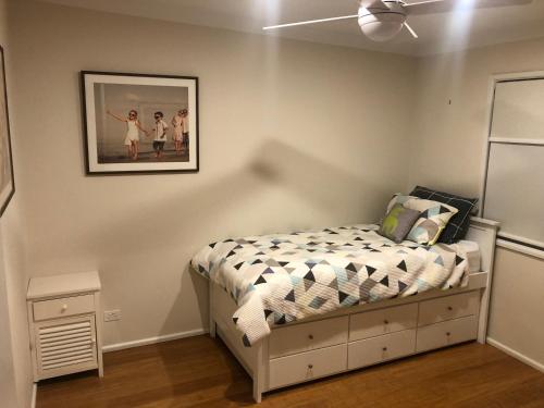 - une chambre dotée d'un lit avec une photo sur le mur dans l'établissement House Beside The Lake, à Summerland Point