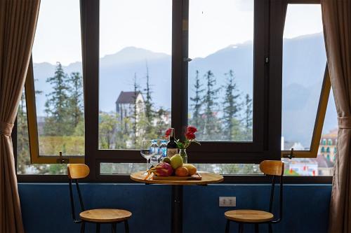 una mesa con una bandeja de fruta delante de una ventana en Le Petit Gecko Hotel en Sa Pa