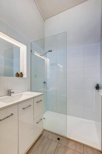a bathroom with a glass shower and a sink at Cedar Cottage Unit 5 in Bright