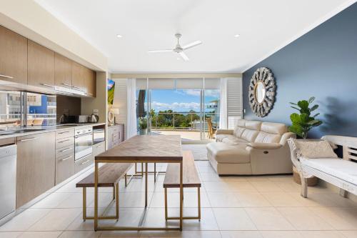 a kitchen and living room with a table and a couch at Vistablue @ the Bay in Urangan