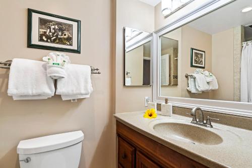 a bathroom with a sink and a toilet and a mirror at Sea Village 1105 in Kailua-Kona