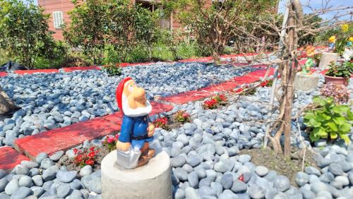 a toy figurine of a woman standing on a rock garden at ChaoPingJia Fengge Guesthouse in Wujie