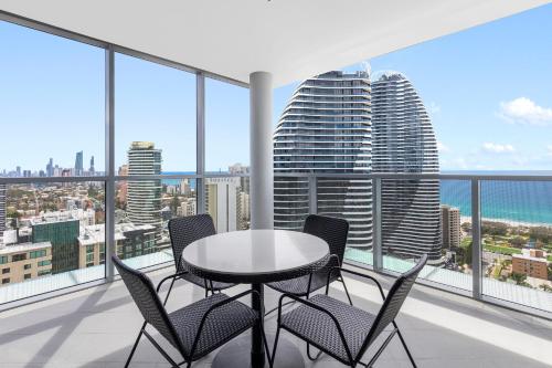 a table and chairs on a balcony with a view of the city at Meriton Suites Broadbeach in Gold Coast