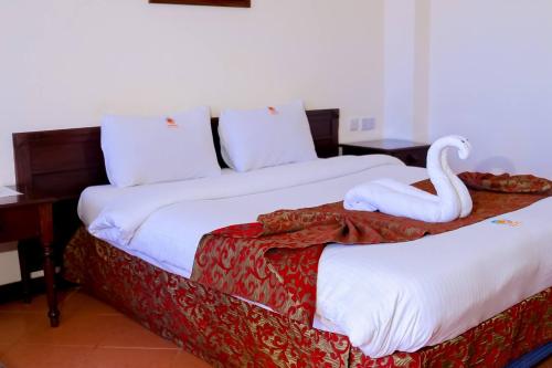 two beds with a swan sitting on top of them at Sunrise Resort Apartments and SPA - Nyali, Mombasa, Kenya in Mombasa