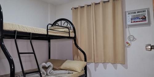 sypialnia z 2 łóżkami piętrowymi i zasłoną w obiekcie CHATEAU DE CHLOE - 3 Bedroom Entire Apartment for Large Group w mieście Tacloban