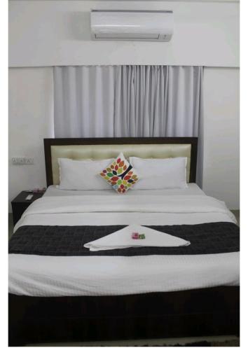 a bed with a tray with a napkin on it at Artist Alley Apartments in Mumbai