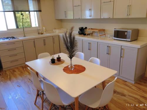 a kitchen with a white table and white chairs at مساكن خاصة بتصميم فندقي ووصول ذاتي in Taif