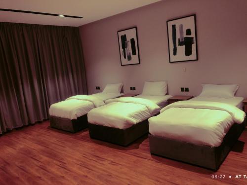 a hotel room with four beds in a room at مساكن خاصة بتصميم فندقي ووصول ذاتي in Taif