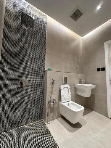 a bathroom with a toilet and a sink and a shower at مساكن خاصة بتصميم فندقي ووصول ذاتي in Taif