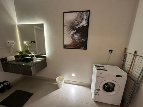 a bathroom with a washing machine and a sink at مساكن خاصة بتصميم فندقي ووصول ذاتي in Taif