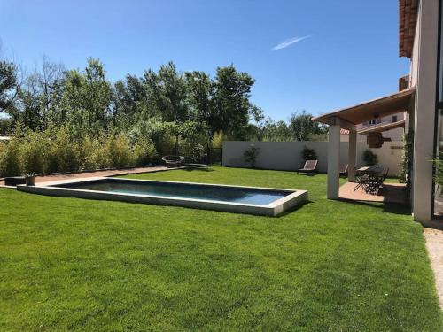 a backyard with a swimming pool in the grass at Villa neuve et moderne avec piscine à Grimaud in Grimaud