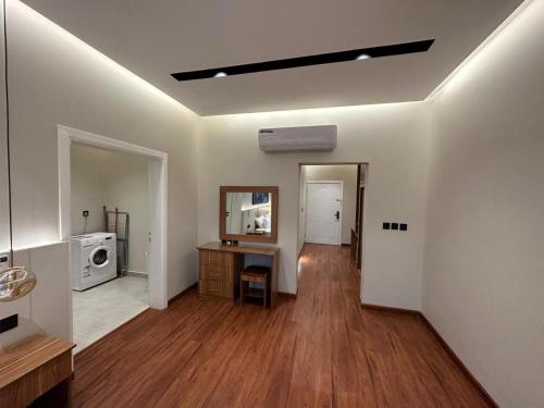 a living room with wooden floors and a room with a microwave at مساكن خاصة بتصميم فندقي ووصول ذاتي in Taif