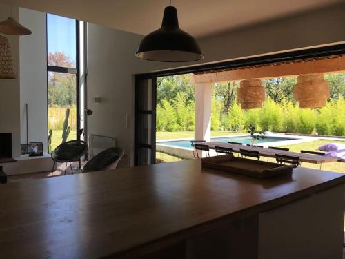 a kitchen with a table and a view of a pool at Villa neuve et moderne avec piscine à Grimaud in Grimaud