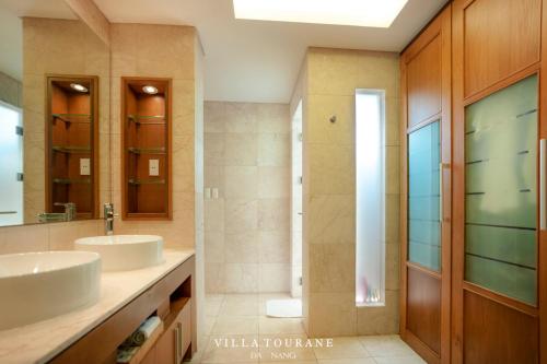 uma casa de banho com 2 lavatórios e um chuveiro em Villa Tourane em Da Nang